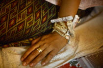 Cambodia, Buddhist wedding ceremony, money attached to wrist.