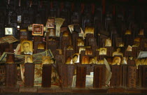 Malaysia, Ancestor worship at chinese temple with photographs of the dead and money offerings.
