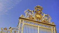 France, Ile de France, Versailles golden entrance gate against blue sky.