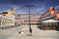 Spain, Extremadura, Badajoz, Colourfully painted buildings in the Plaza Alta with Espantaperros tower behind.