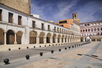 Spain, Extremadura, Badajoz, Colourfully painted buildings in the Plaza Alta with Espantaperros tower behind.