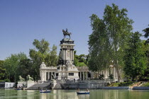 Spain, Madrid, Monument to King Alfonso XII in Parque El Buen Retiro with tourist boating inthe lake.