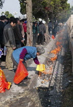 China, Jiangsu, Qidong, Qingming Festival when Chinese people honour their ancestors and deceased family members by visiting their graves or burial grounds to make offerings of fake bank notes and gol...