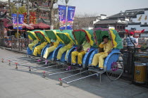 China, Jiangsu, Nanjing, Row of rickshaws with the rickshaw pullers in yellow uniform and hats asleep outside the Fuzi Temple, a top tourist spot, Fuzi Temple complex tile roofs and red Chinese lanter...