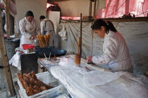 China, Jiangsu, Nanjing, Road-side bakery shop, baker cutting strips of dough that will be twisted and deep-fried in a wok to ptoduce Yu Tiao a popular breakfast bread usually eaten with warm soyamilk...