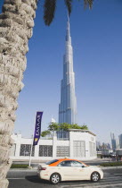 United Arab Emirates, Dubai, Taxi passes Burj Khalifa tower.
