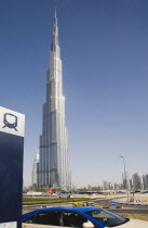 United Arab Emirates, Dubai, Metro sign and taxi in front of Burj Khalifa tower.