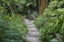 Urban garden with pebble path and railway sleepers.