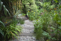 Urban garden with pebble path and railway sleepers.