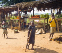 Burundi, Cibitoke Province, Buganda Commune, Market stall selling vegetables beside the road. Francine, a 9 year old girl with special needs, unable to attend school which is 4 miles a away.