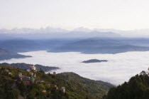 Nepal, Nagarkot, View across clouded valley towards Himalayan mountains.