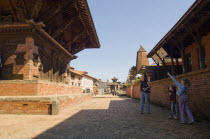 Nepal, Bhaktapur, Durbar Square, Tourist children pointing at a building.