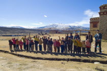 China, Szechuan Province, Tibet, School children waving outside their school.