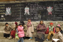 China, Szechuan Province, Litang County, Parents, grandparents and children at the entrance to a private boarding school in Tibetan region.