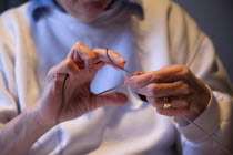 Woman hand knitting wool together with needles.