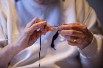 Woman hand knitting wool together with needles.