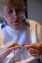 Woman hand knitting wool together with needles.