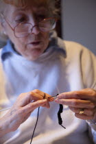 Woman hand knitting wool together with needles.