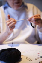 Woman hand knitting wool together with needles.