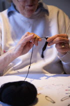 Woman hand knitting wool together with needles.