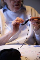 Woman hand knitting wool together with needles.