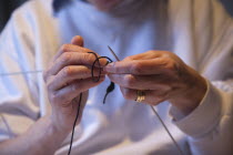 Woman hand knitting wool together with needles.