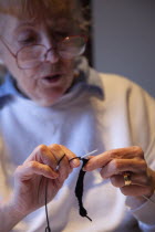 Woman hand knitting wool together with needles.