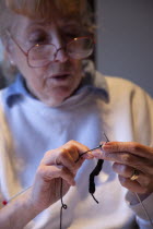 Woman hand knitting wool together with needles.