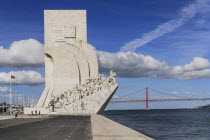 Portugal, Estremadura, Lisbon, Padrao dos Descobrimentos, Carving of Prince Henry the Navigator leading the Discoveries Monument with the Ponte 25th Abril Bridge behind.