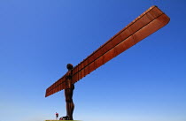 England, Tyne and Wear, Gateshead, Angel Of The North, Steel Sculpture Standing 20 Metres High Designed By Antony Gormley, Man Standing At Base With Child.