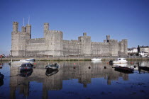 Wales, Gwynedd, Caernarfon Castle Against Deep Blue Sky, Overlooking The River Seiont as the tide comes in, Construction Started In 1283, And Prince Charles Held His Investiture At The Castle In 1969....