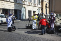 Italy, Lazio, Rome, Tourists dressed as Bishops to take tour on Segways.