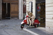 Italy, Lazio, Rome, Mannequin seated on Vespa outside tourist shop.