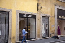 Italy, Lazio, Rome, Via del Condotti, Exterior of the Valentino designer clothing shop with woman begging outside. **Editorial Use Only**