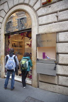 Italy, Lazio, Rome, Via del Condotti, Tourists looking at shoe display in the Jimmy Choo shop. **Editorial Use Only**