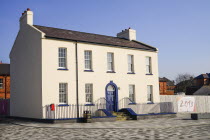 Ireland, Derry, Former Ebrington Barracks building with blue doorway and small Derry 2013 Year of Culture banner.
