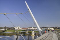 Ireland, Derry, The Peace Bridge over the River Foyle opened in 2011 with the former Ebrington Barracks in the background.