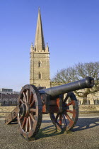 Ireland, Derry, St Columb's Cathedral with cannon on city walls in the foreground.