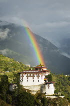 Bhutan, Lhuentse Dzong with colourful rainbow overhead.