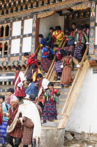 Bhutan, Gangtey Gompa, Tsecchu festival crowds descending temple steps dressed in their best clothes.