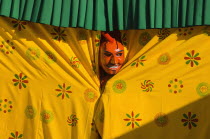 Bhutan, Thimpu Dzong, Atsara, or comedian peering out from behind a curtain at a masked dance Tsecchu.