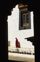 Bhutan, Tango Buddhist Monastery, Monk standing in the courtyard.