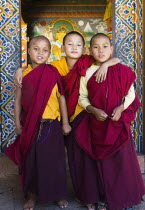 Boy Monks standing in doorway of Chimi Lakhang (Buddhist temple), Punakha, Bhutan.