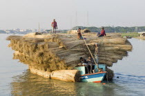 Bangladesh, Boat heavily laden with a cargo of jute stems on river.