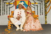 Bangladesh, Dhaka, Bride and groom dressed up in glitzy jewellery and flowers for their wedding.