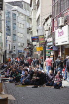 Turkey, Istanbul, Fatih, Sultanahmet, Men sat in street in readiness for midday prayers.