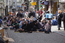 Turkey, Istanbul, Fatih, Sultanahmet, Men sat in street in readiness for midday prayers.