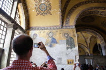 Turkey, Istanbul, Fatih, Sultanahmet, Tourist photographing religious mosiac in Haghia Sofia.