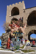 Spain, Valencia Province, Valencia, Grotesque Papier Mache figure at the Serranos Towers during Las Fallas festival.