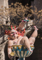 Spain, Valencia Province, Valencia, Grotesque Papier Mache figure at the Serranos Towers during Las Fallas festival.